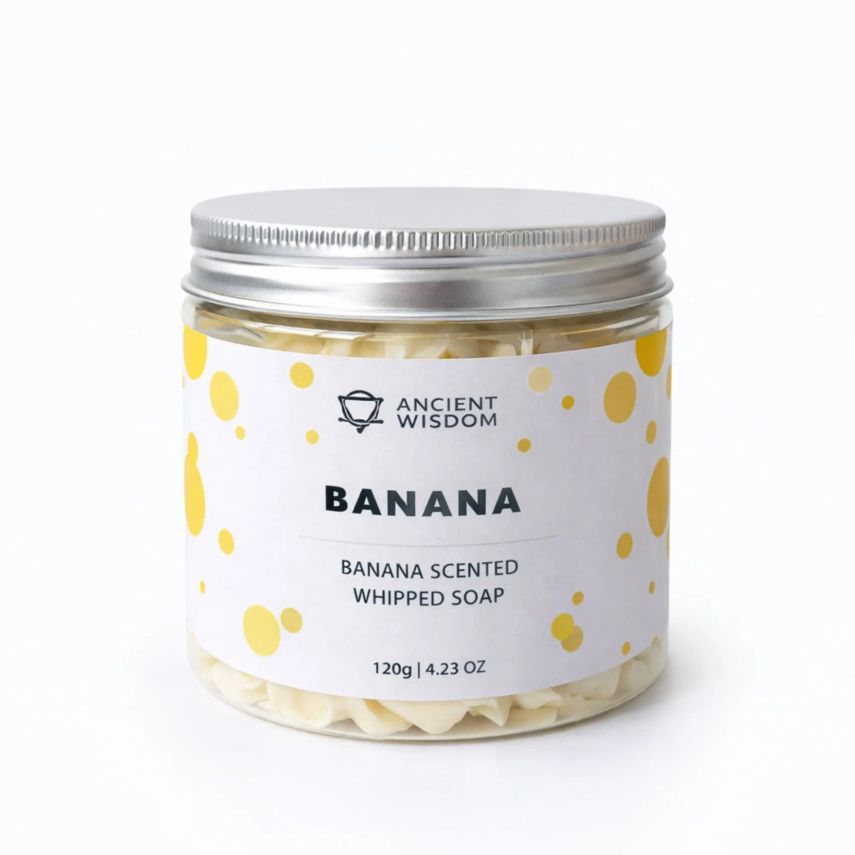 Jabón batido con aroma a plátano, 120g, en frasco de vidrio con tapa plateada y etiqueta blanca con puntos amarillos.