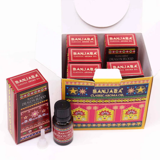 Caja abierta y frasco de aceite aromático con diseño decorativo colorido y motivos florales en tonos rojos y dorados.