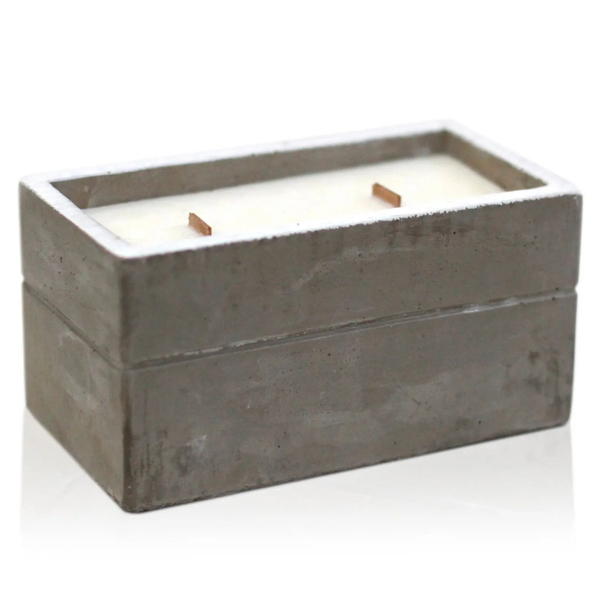 Vela rectangular de hormigón gris con dos mechas de madera y cera blanca, estilo minimalista y natural.