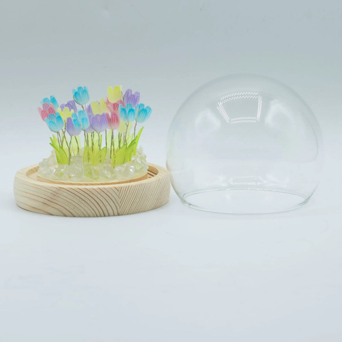 Domo de cristal con 20 tulipanes LED multicolor sobre base de madera clara. Diseño Floral Glow de Ancient Wisdom.