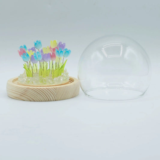 Domo de cristal con 20 tulipanes LED multicolor sobre base de madera clara. Diseño Floral Glow de Ancient Wisdom.