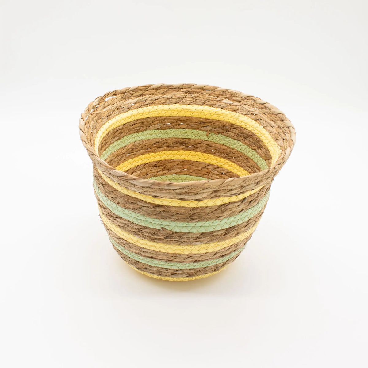 Cesta en forma de jarrón tejida con hierba marina, fibras naturales, detalles en bandas amarillas y verdes.