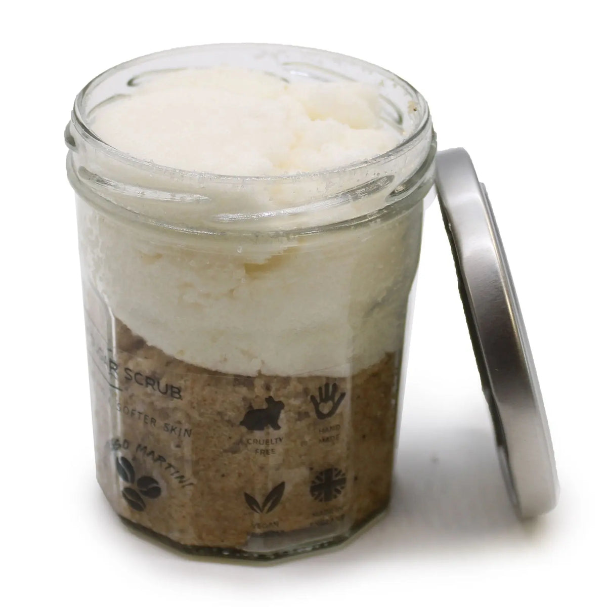 Exfoliante corporal de azúcar en frasco de vidrio: capa superior blanca y base de café, con tapa metálica lateral.