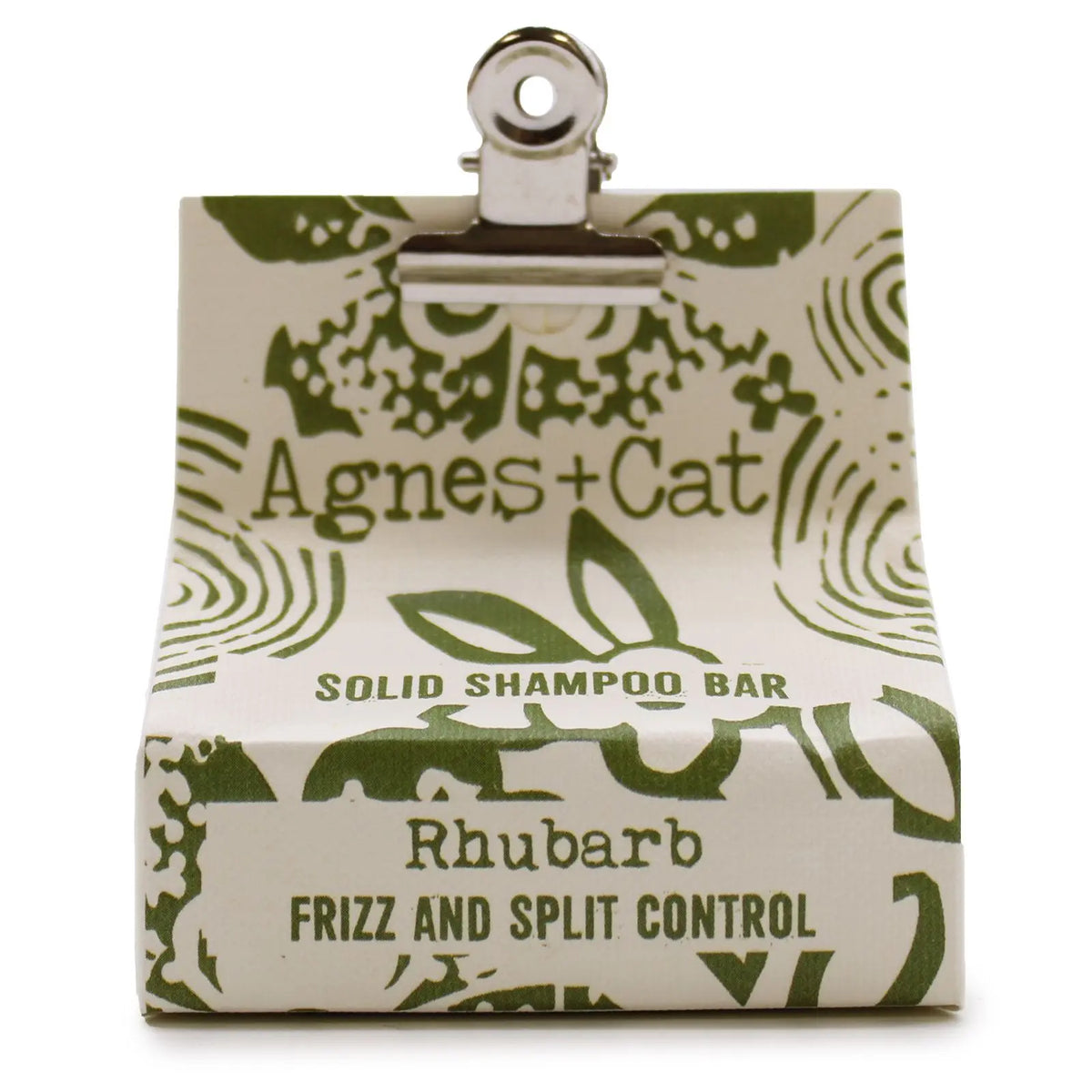 Champú sólido Agnes+Cat de ruibarbo en empaque de papel crema con estampado botánico verde, sujeto por una pinza metal.
