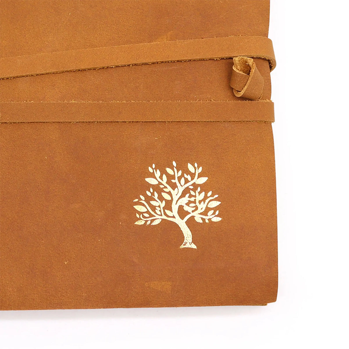 Cuaderno de viaje en cuero marrón con cierre de tira y un árbol grabado en color dorado. Estilo rústico.