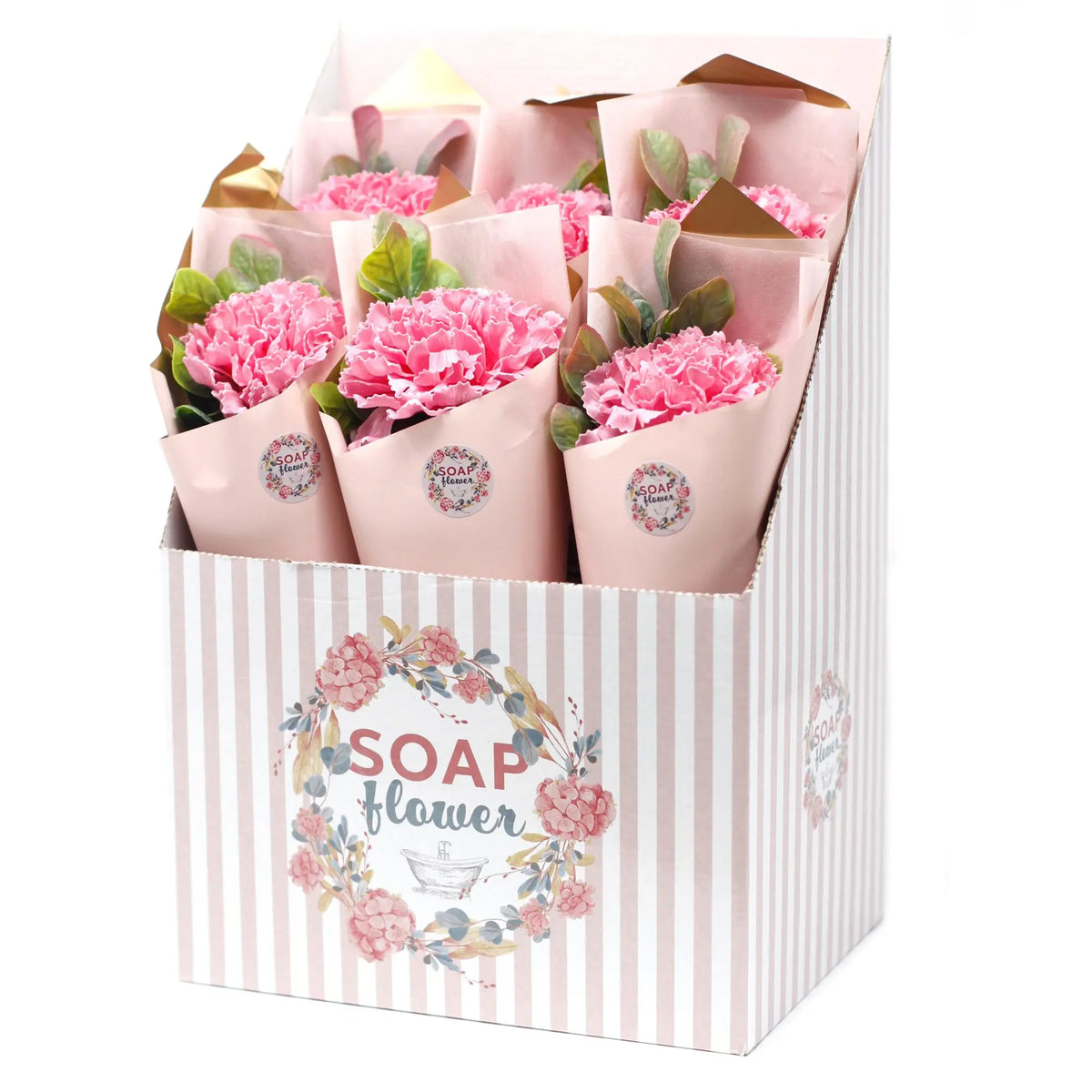 Expositor con ramos de claveles de jabón rosados envueltos en papel artesanal, presentados en una caja a rayas.