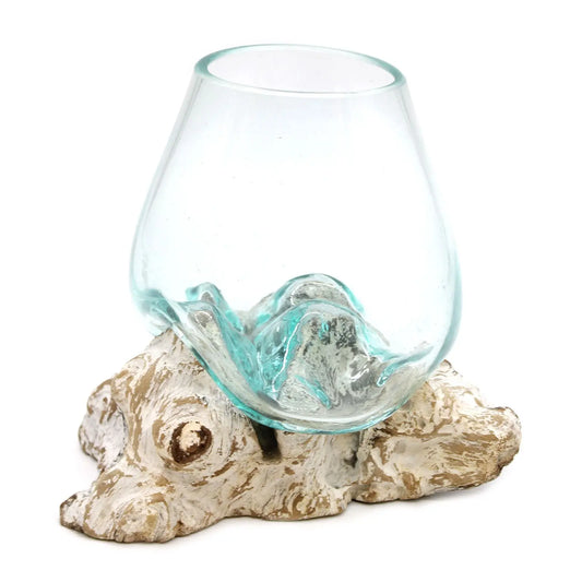 Cuenco de vidrio fundido transparente moldeado sobre una base de madera natural blanqueada de formas orgánicas.