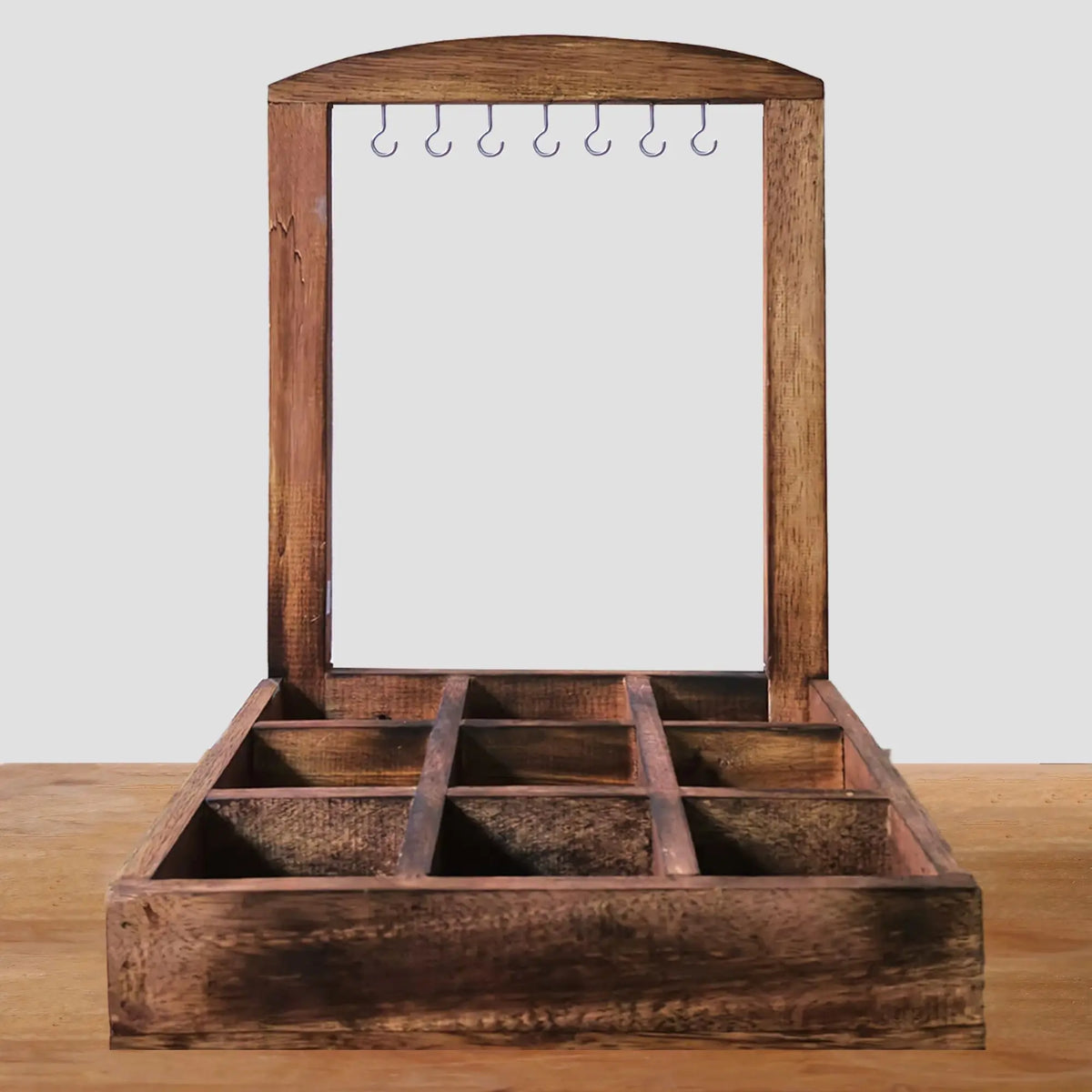 Exhibidor artesanal de madera oscura con 9 compartimentos y ganchos superiores para colgar joyería. Estilo rústico.