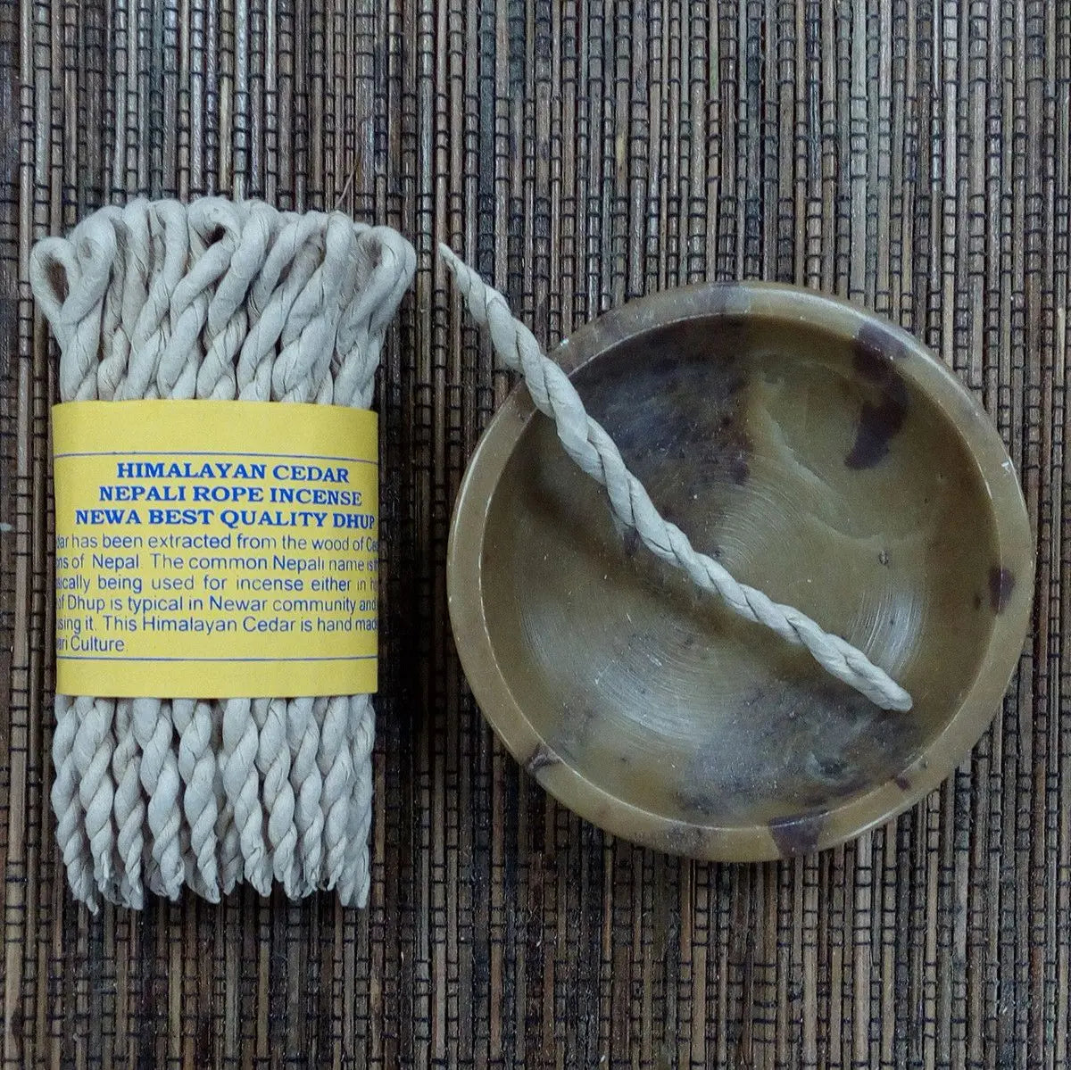 Incienso de cuerda de cedro himalayo, color beige, acompañado de soporte redondo de cerámica, estilo artesanal.