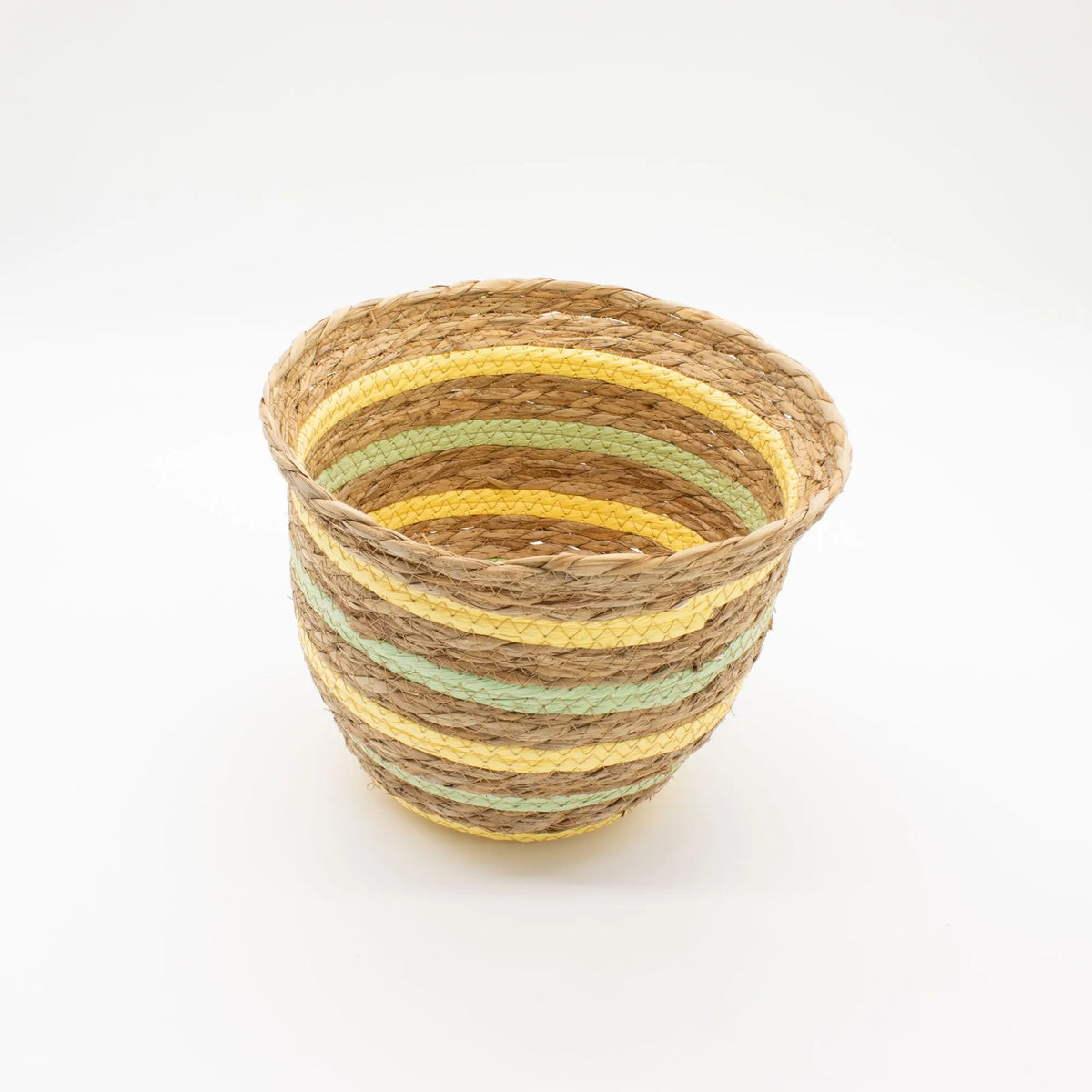 Cesta artesanal de hierba marina en forma de jarrón, con fibras naturales tejidas en rayas amarillas y verdes.