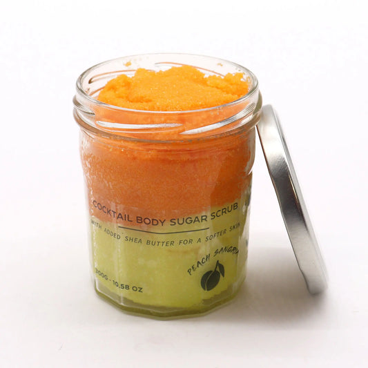 Frasco de vidrio con exfoliante de azúcar en capas naranja y amarilla, tapa metálica a un lado, fondo blanco.