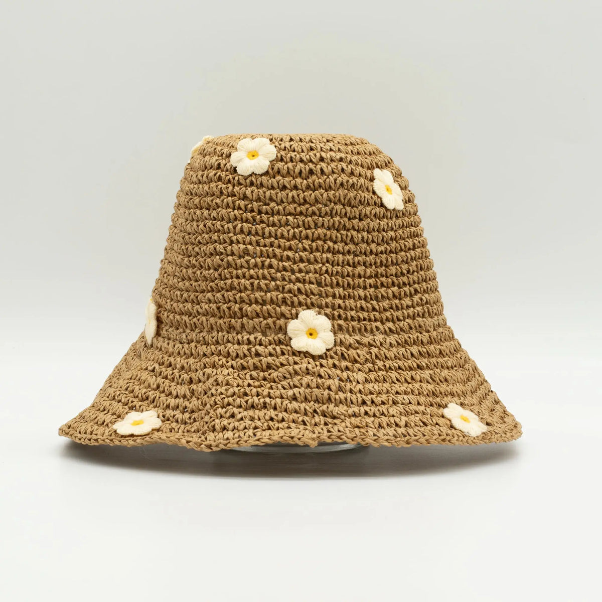 Sombrero de paja marrón con flores bordadas en blanco y amarillo, estilo veraniego y casual.
