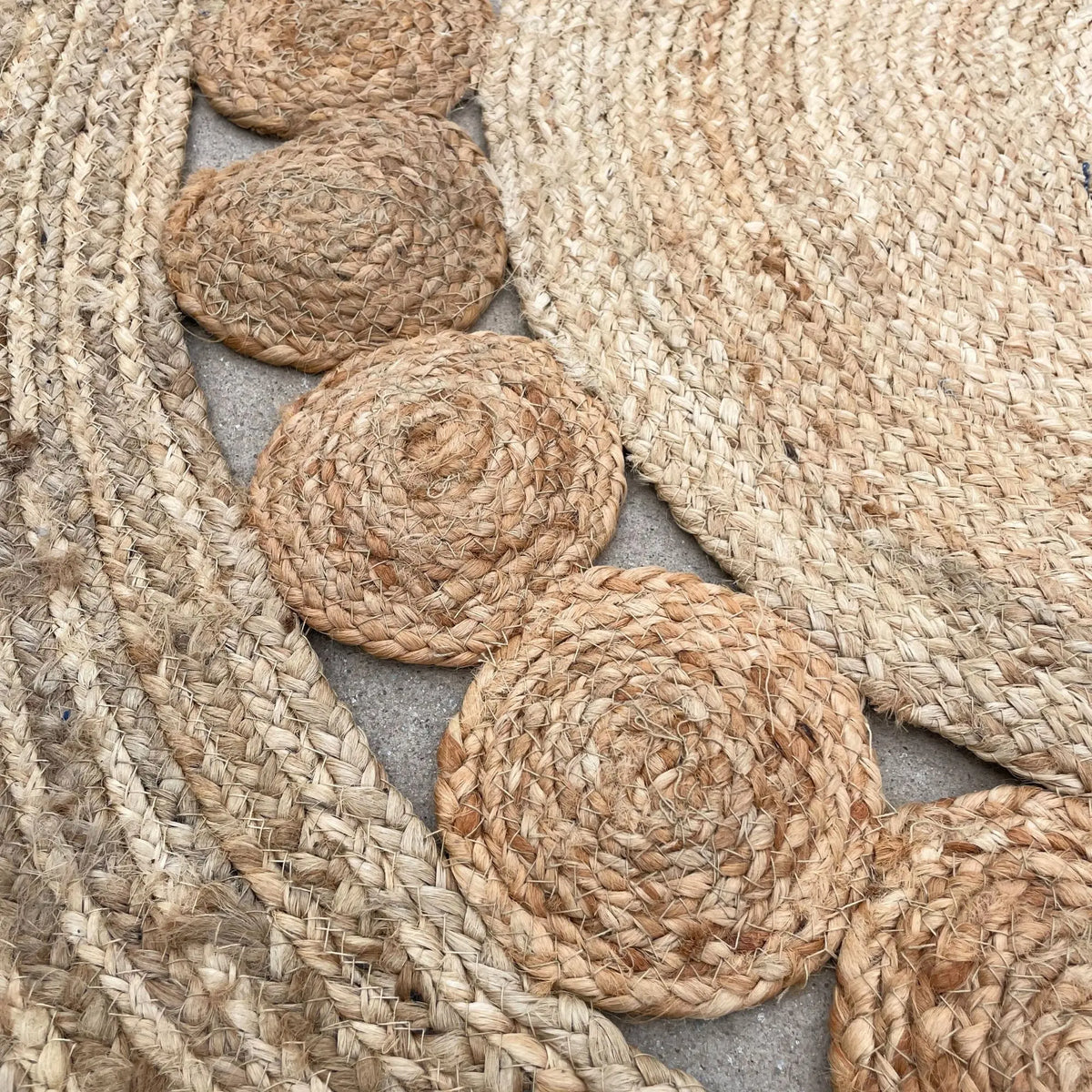 Alfombra redonda artesanal de yute con textura trenzada y detalles circulares en relieve. Tono natural beige.
