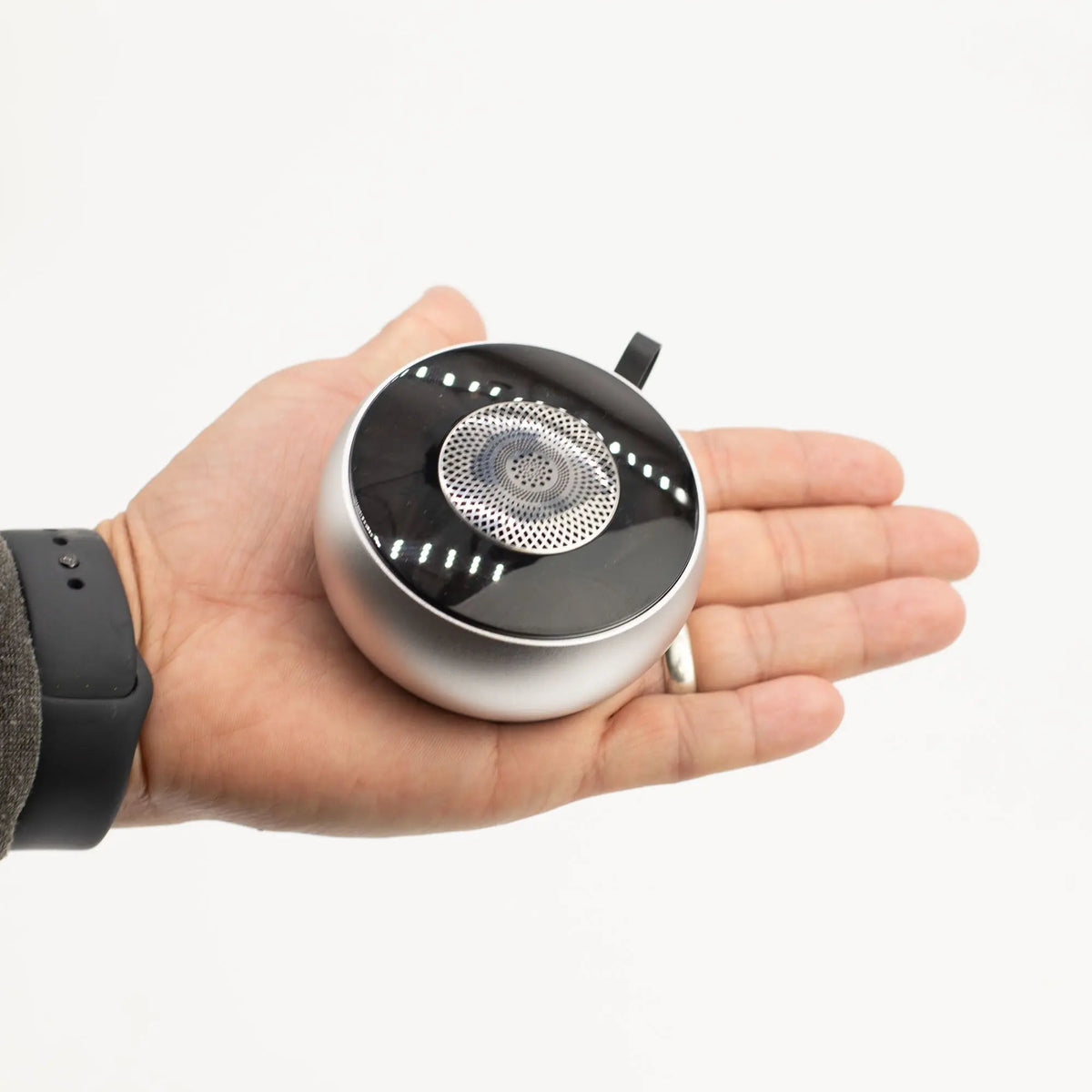 Mini altavoz Bluetooth Ancient Wisdom, redondo y plateado, con rejilla superior y efecto de iluminación mandala.
