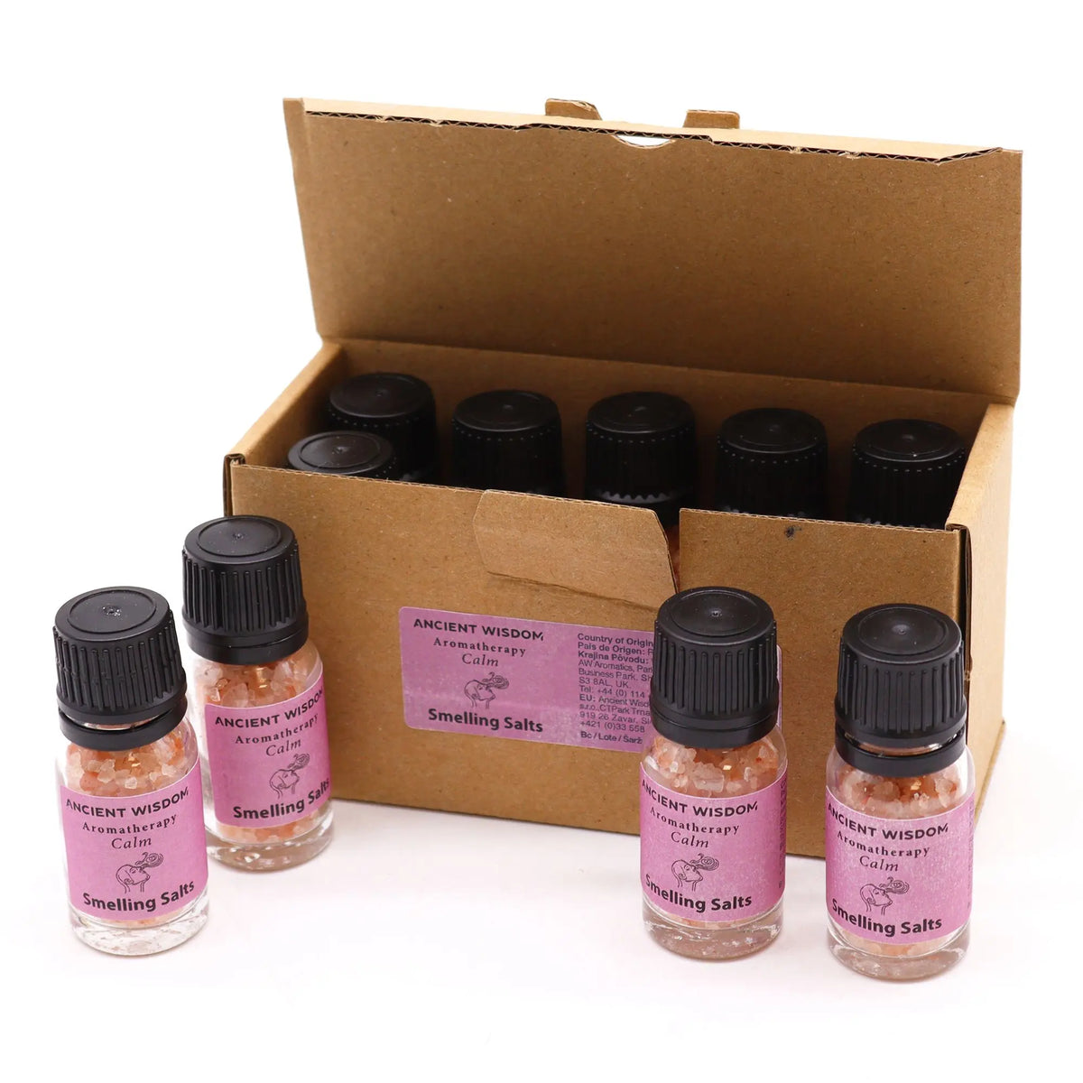 Frascos pequeños con sales rosadas y tapa negra, junto a una caja de cartón con varios viales de aromaterapia.