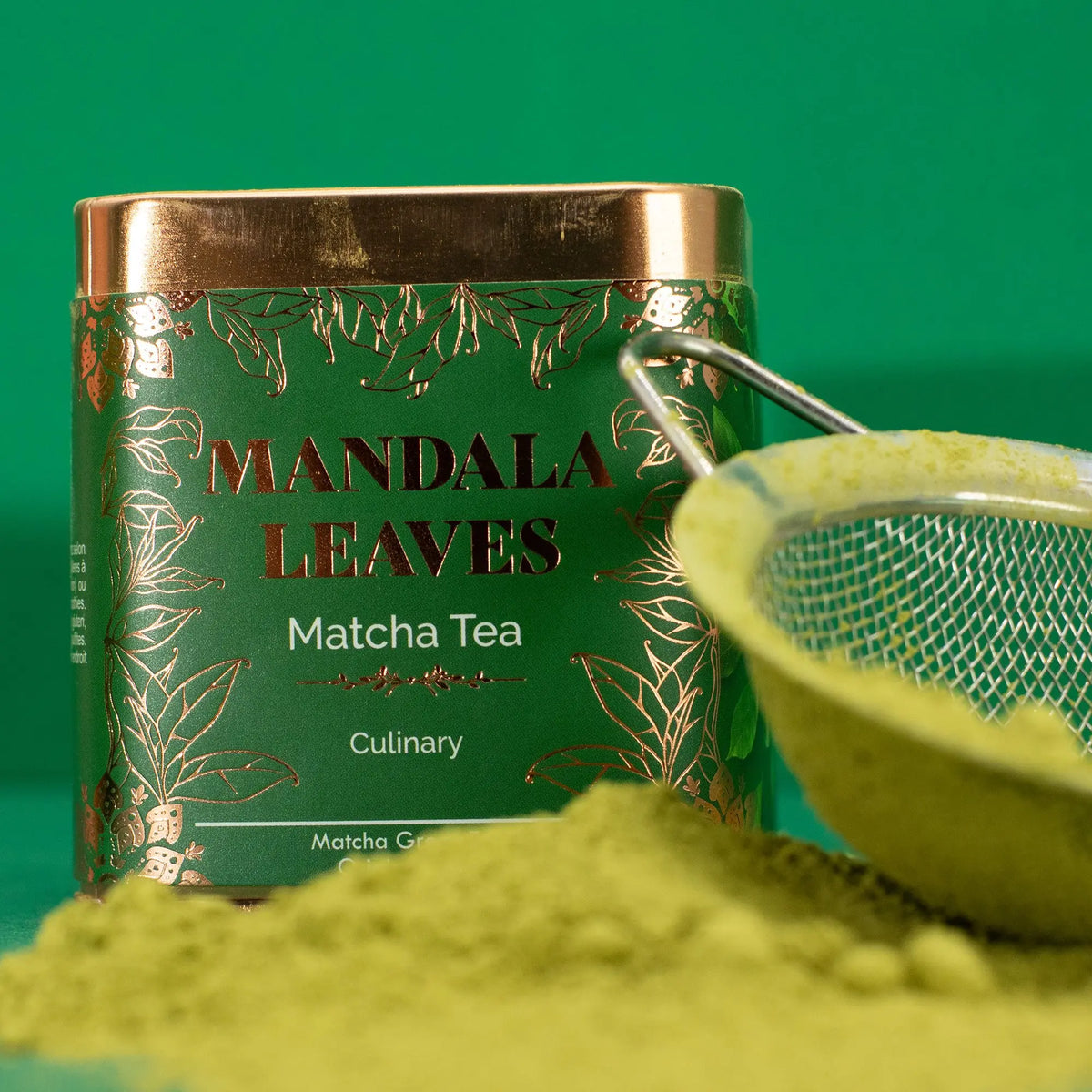 Lata verde de té matcha junto a un colador con polvo de té sobre fondo verde. Diseño artesanal con detalles dorados.