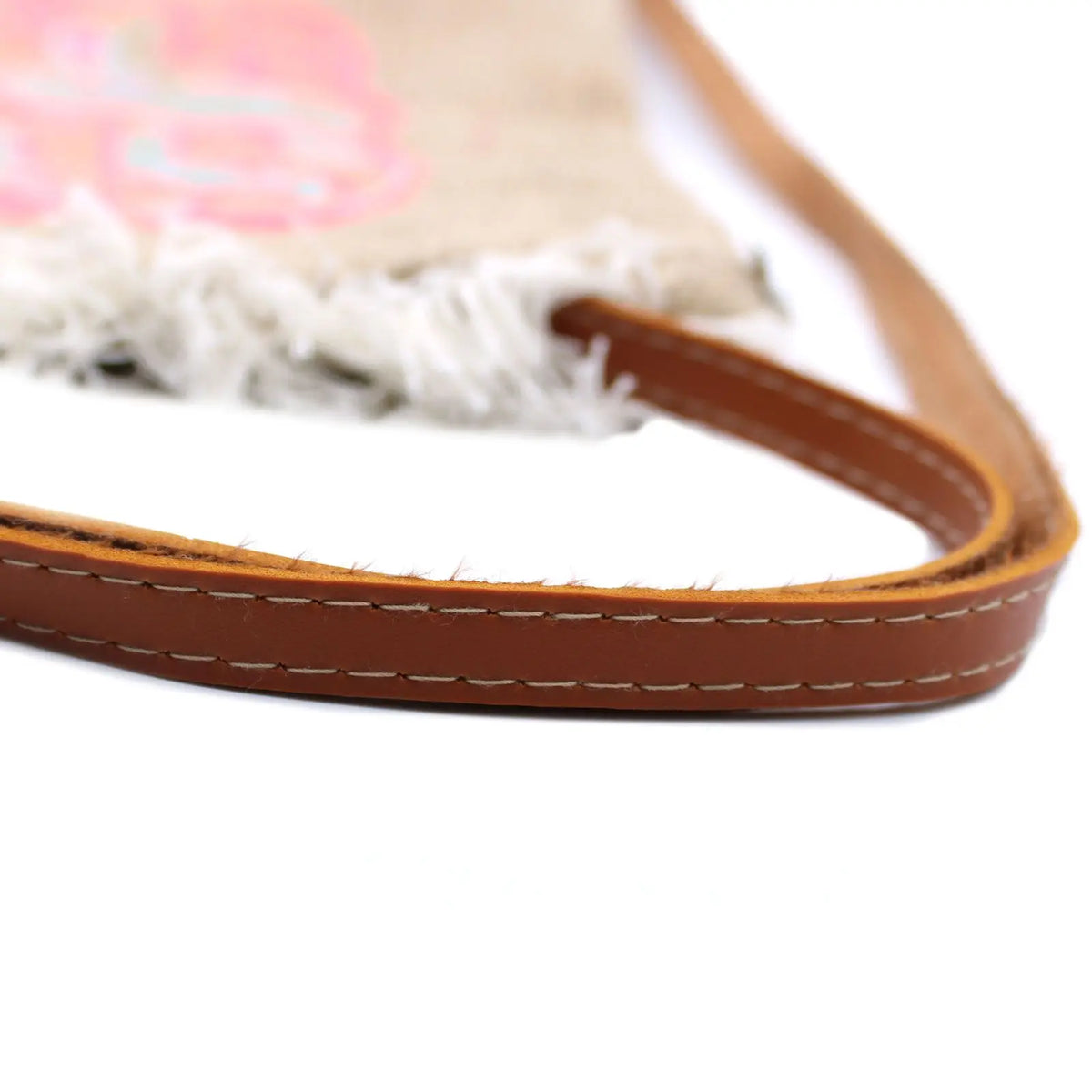 Bolso de yute con flecos blancos, estampado de piña rosa y correas de piel sintética marrón con costuras visibles.
