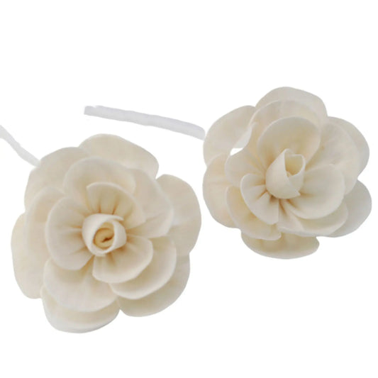 Dos flores difusoras de loto color crema hechas de madera natural sobre cuerda blanca sobre fondo blanco