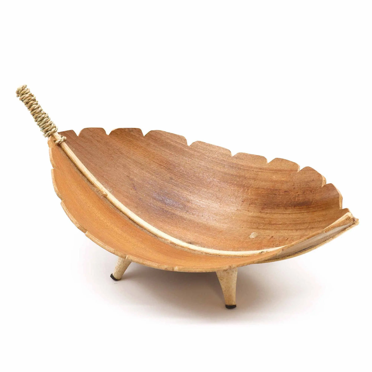 Frutero artesanal con forma de hoja de coco en madera natural, sobre tres patas pequeñas y detalle de cuerda decorativa.