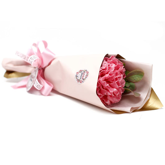 Ramo de regalo con un clavel de jabón rosa, envuelto en papel decorativo y decorado con un lazo de satén rosa.