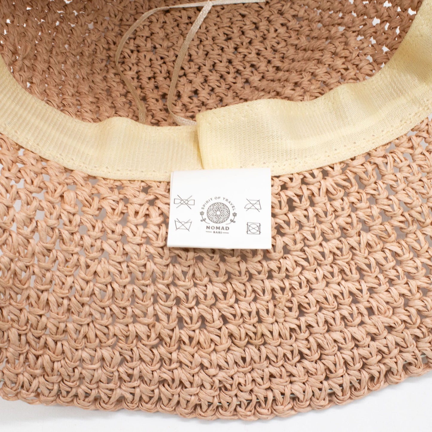 Sombrero tejido en tono rosa claro con cinta amarilla, ideal para la temporada de verano. Marca: Nomad.