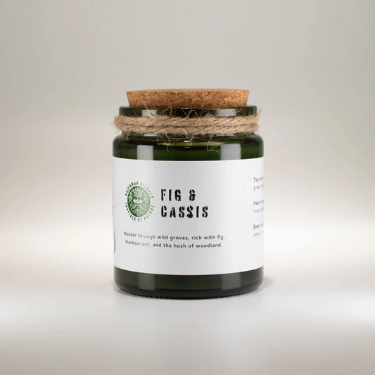 Vela de cristal verde con tapa de corcho, aroma higo y grosella negra, estilo rústico.