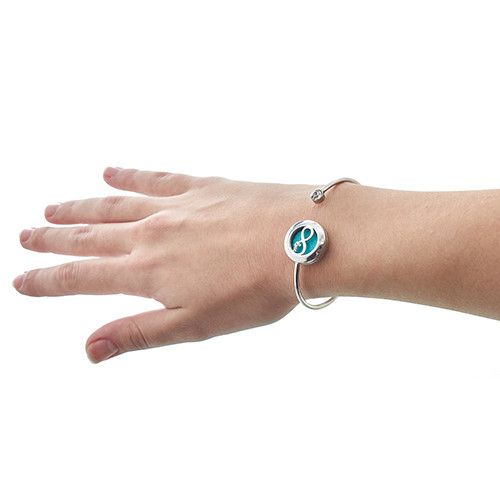 Pulsera de acero inoxidable plateado con un charm circular azul claro, estilo moderno y elegante.