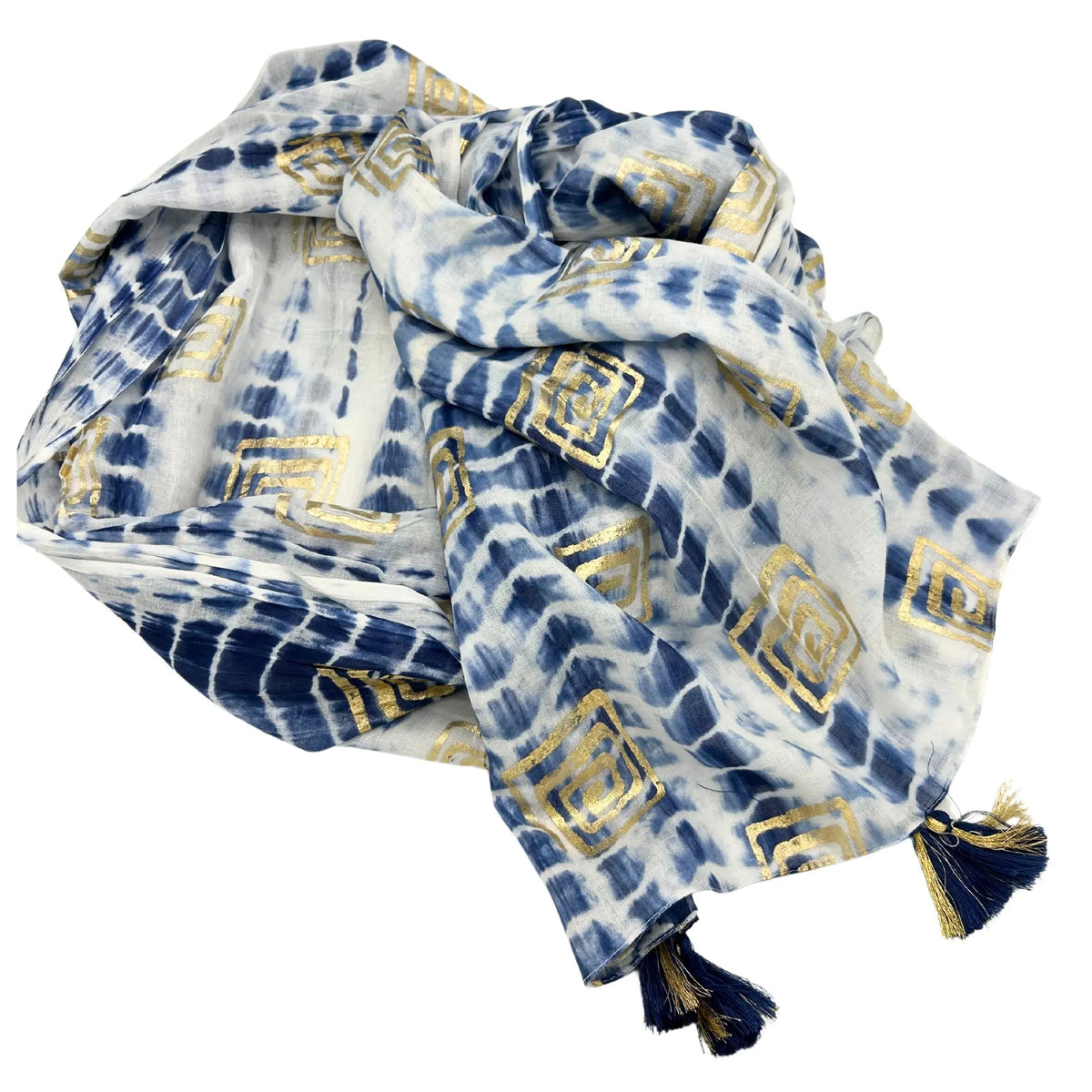 Pareo de algodón blanco y azul con efecto tie-dye, estampado geométrico dorado y borlas en las esquinas.