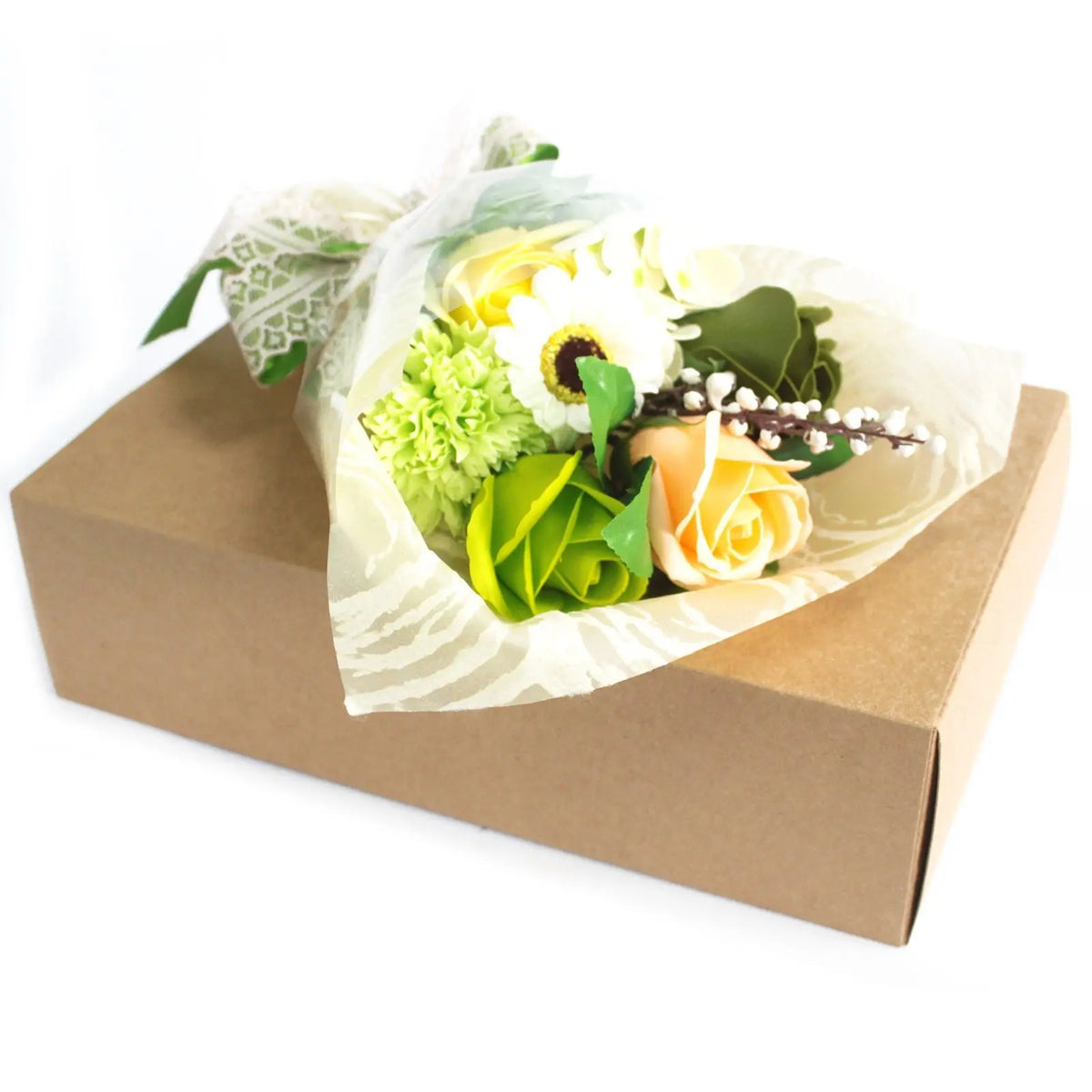 Bouquet de flores de jabón verdes, amarillas y blancas en papel decorativo sobre una caja de cartón rectangular.