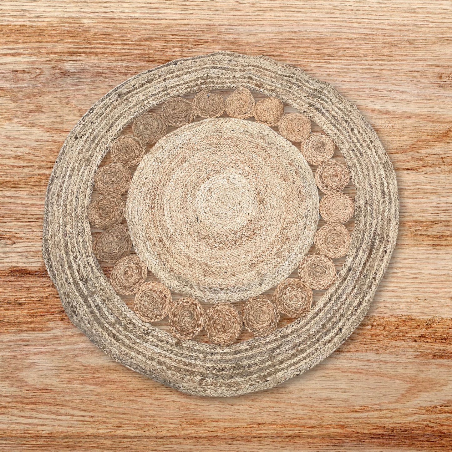 Alfombra redonda artesanal de yute y algodón natural con diseño de círculos entrelazados en tonos tierra sobre madera