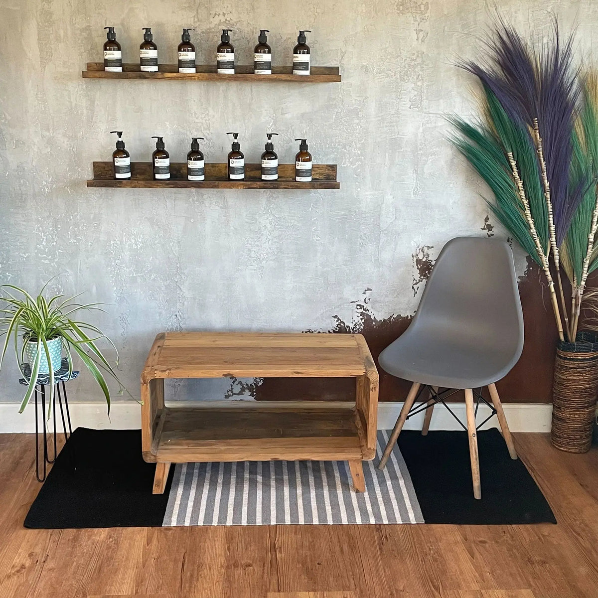 Alfombra de algodón rectangular (70x170cm) con diseño a rayas grises en el centro y extremos negros sobre suelo madera.