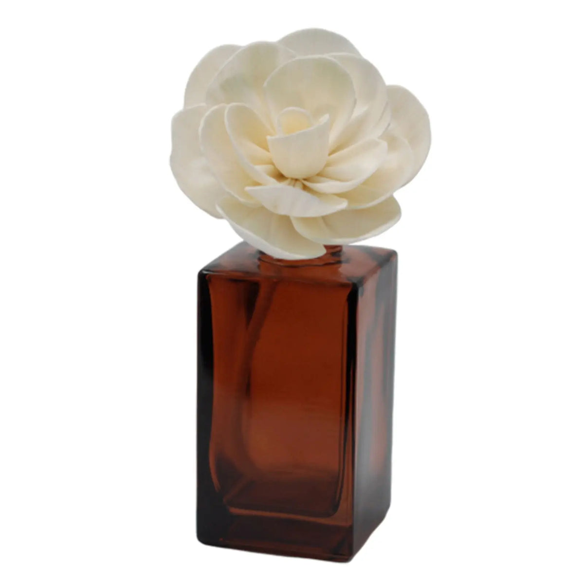 Flor de loto artesanal de madera clara en frasco de vidrio color ámbar cuadrado para difusor de fragancias.