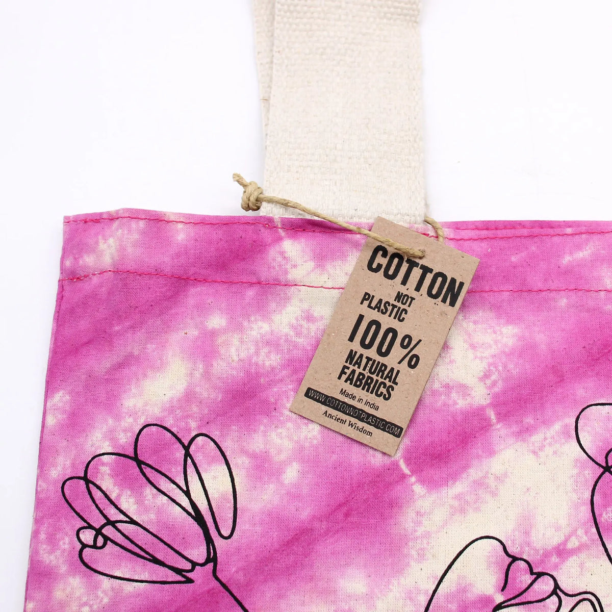 Bolsa de algodón tie-dye rosa y blanco con diseño de líneas negras y etiqueta informativa de cartón reciclado.