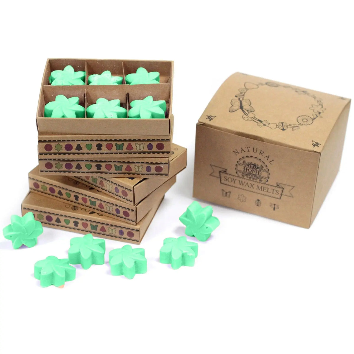 Cajas de cartón kraft apiladas con 6 ceras de soja verde en forma de flor, junto a una caja cerrada con motivos.