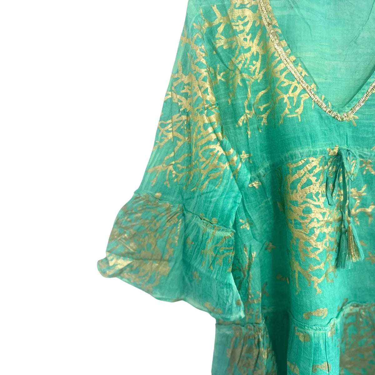 Vestido turquesa con estampado de coral dorado, escote en V con detalle de lentejuelas y mangas con volante.