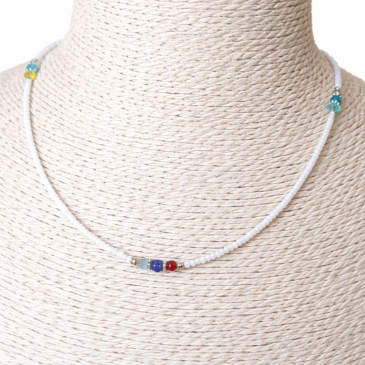 Collar de cuentas blancas con detalles en azul, rojo y verde, un estilo fresco y colorido.