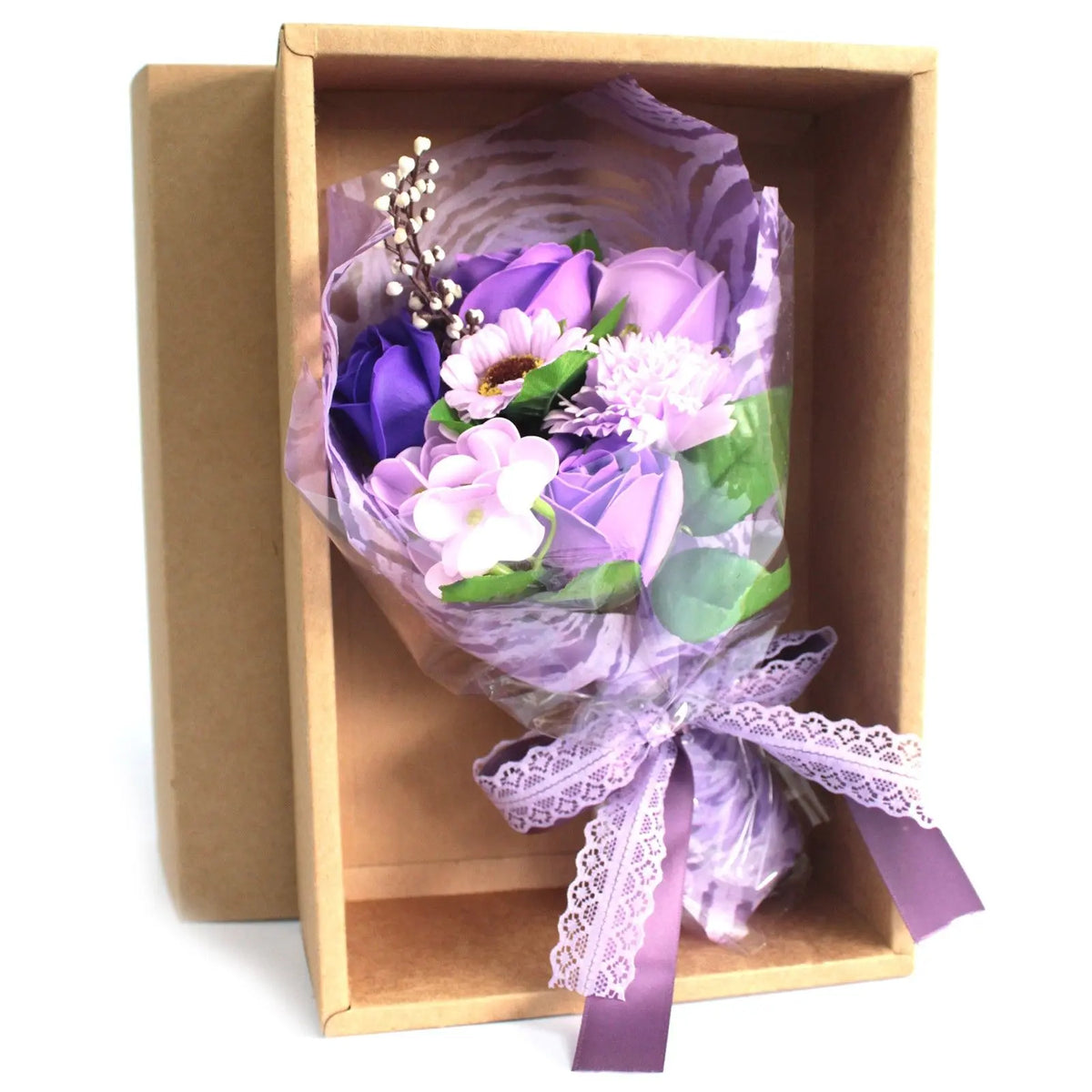 Bouquet de flores de jabón en tonos púrpura, envuelto en papel transparente y lazo decorativo dentro de una caja craft.