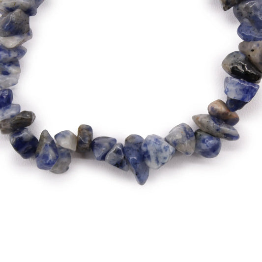 Pulsera de fragmentos de piedra sodalita natural en tonos azul y gris sobre fondo blanco.
