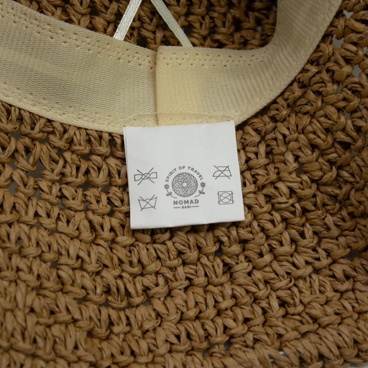 Gorro de paja trenzada color natural con cinta beige, estilo bohemio, ideal para días soleados.