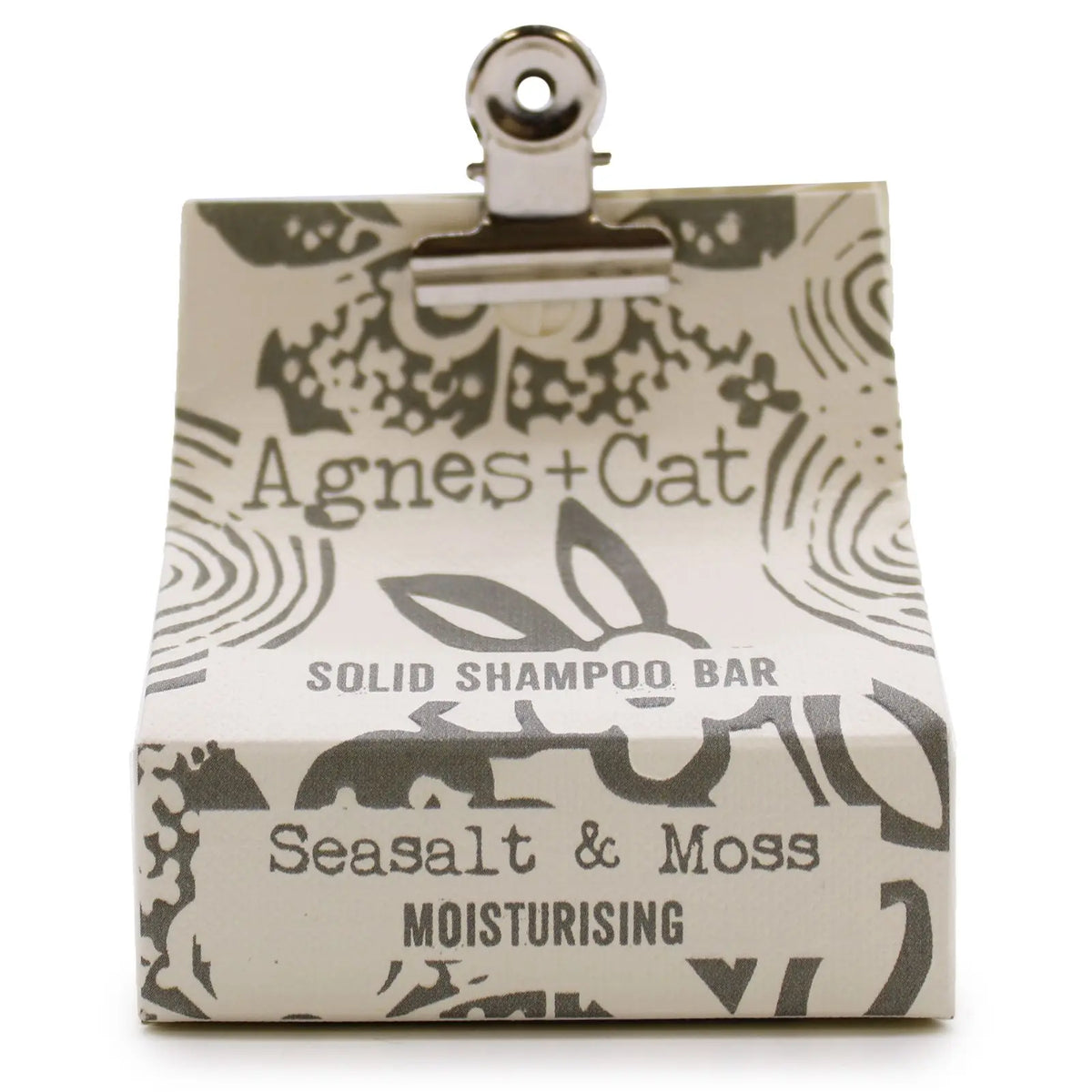 Champú sólido Agnes+Cat de sal marina y musgo en caja de cartón beige con estampado gris sujeta por un clip metálico.