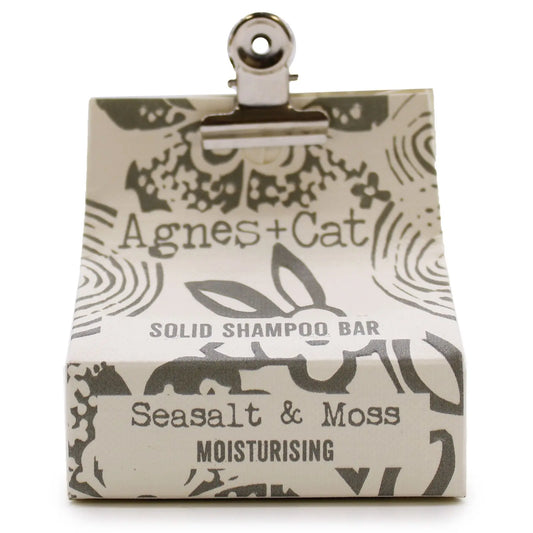 Champú sólido Agnes+Cat de sal marina y musgo en caja de cartón beige con estampado gris sujeta por un clip metálico.