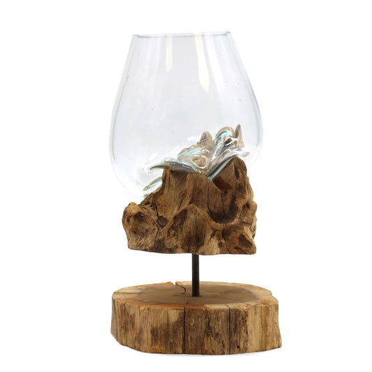 Cuenco de vidrio fundido transparente moldeado sobre madera natural, apoyado en un soporte de madera circular.