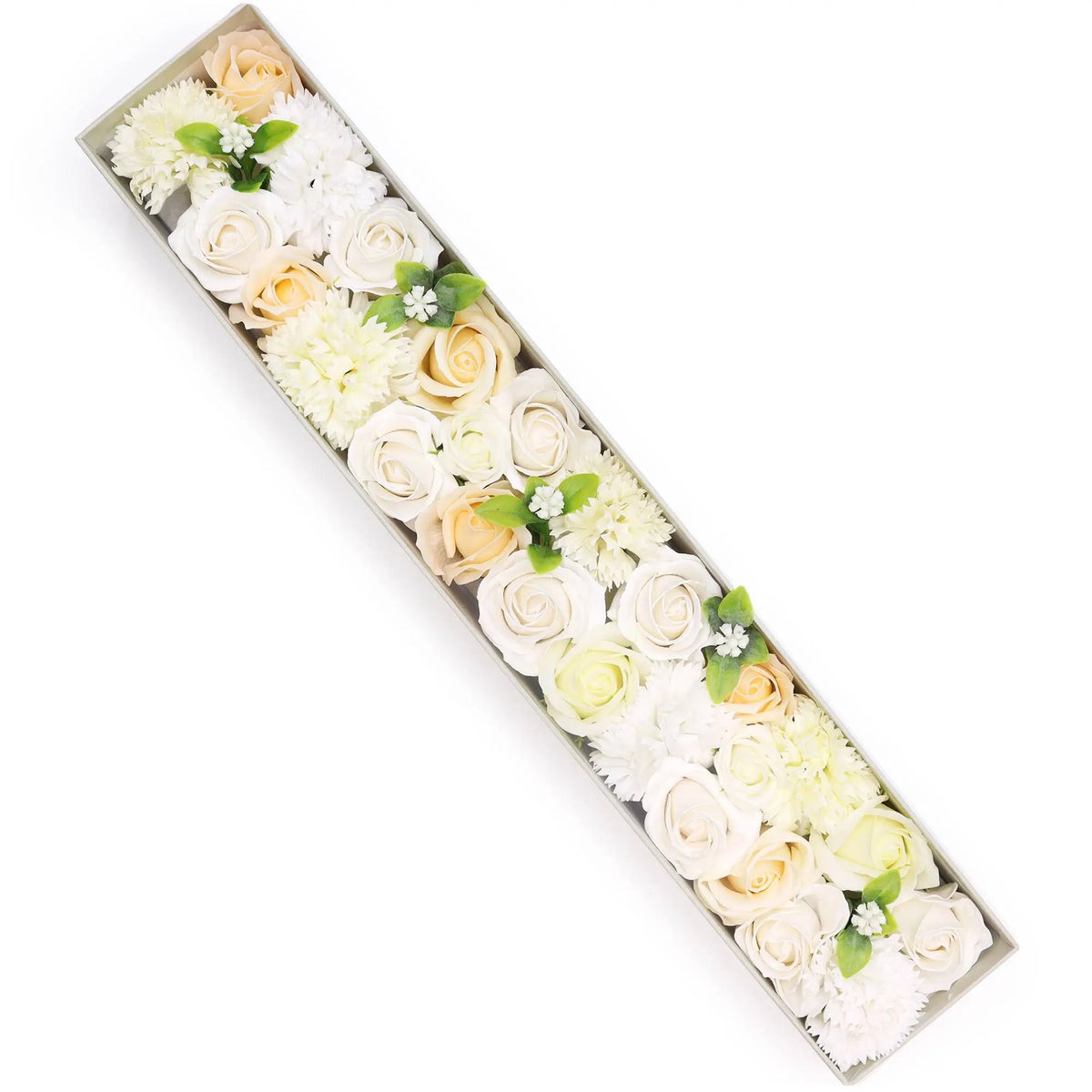 Caja alargada con rosas y claveles de jabón en tonos blanco y marfil, decorada con pequeñas hojas verdes.