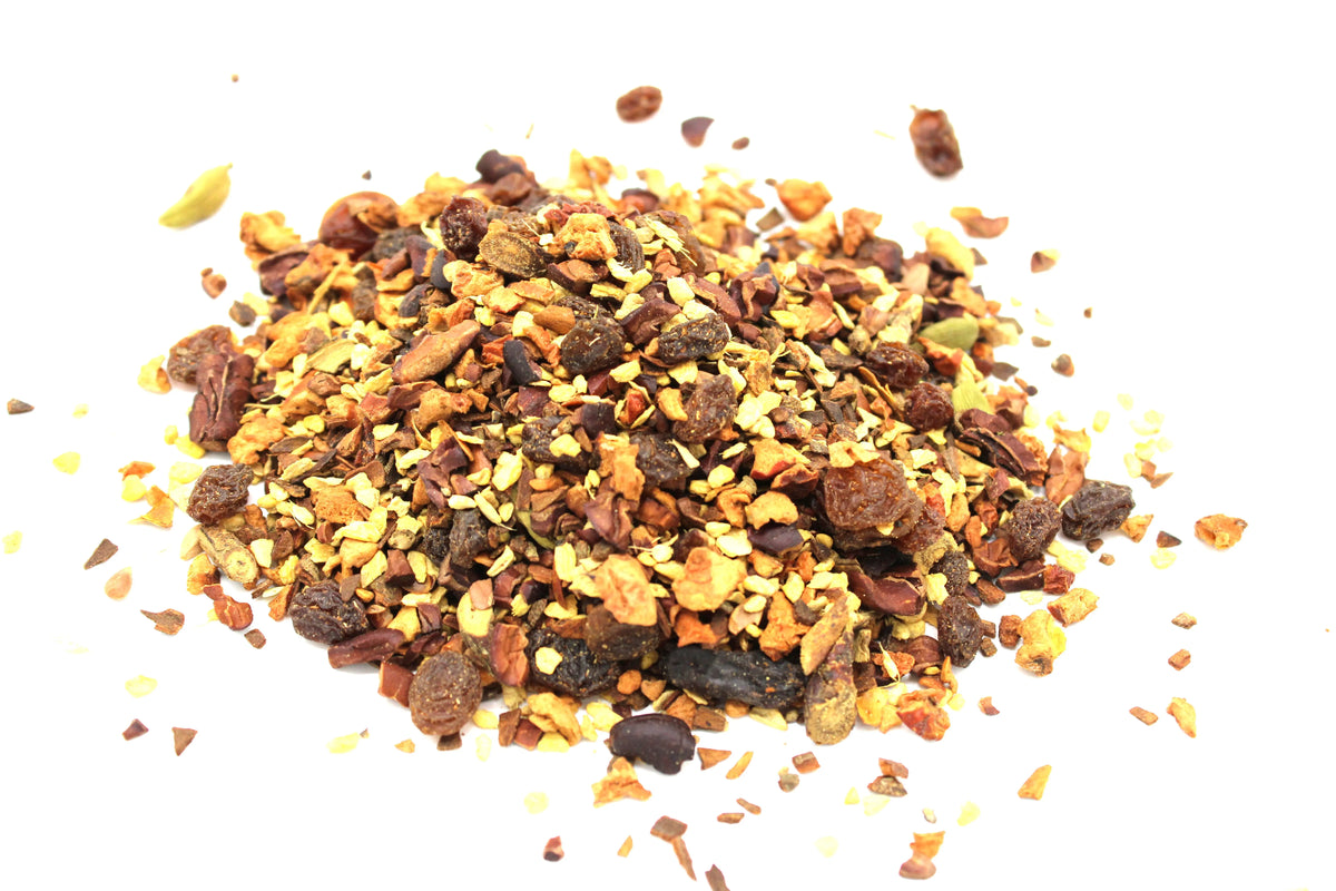 Montículo de infusión de chocolate con especias trozos de cacao pasas y cardamomo sobre fondo blanco aislado