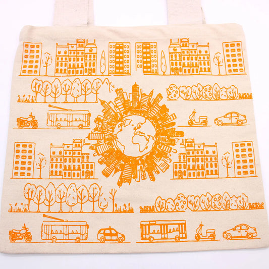Bolsa de tela color crema con estampado naranja de edificios, vehículos y un globo terráqueo rodeado de rascacielos.