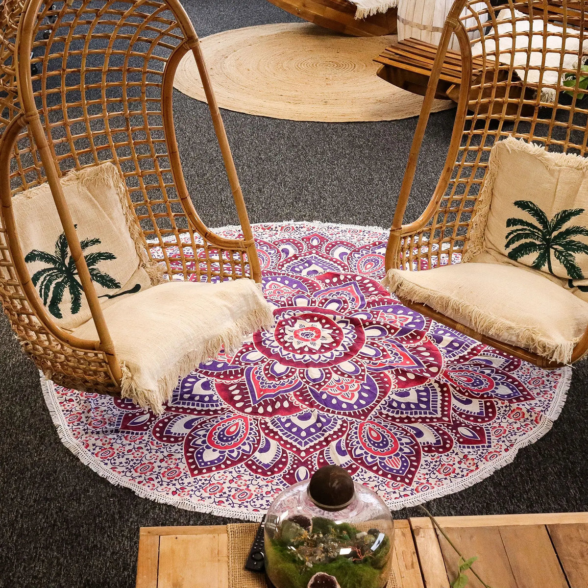 Tapiz redondo de algodón de 180 cm con diseño de mandala en tonos rosa y morado, con borde de flecos decorativos.