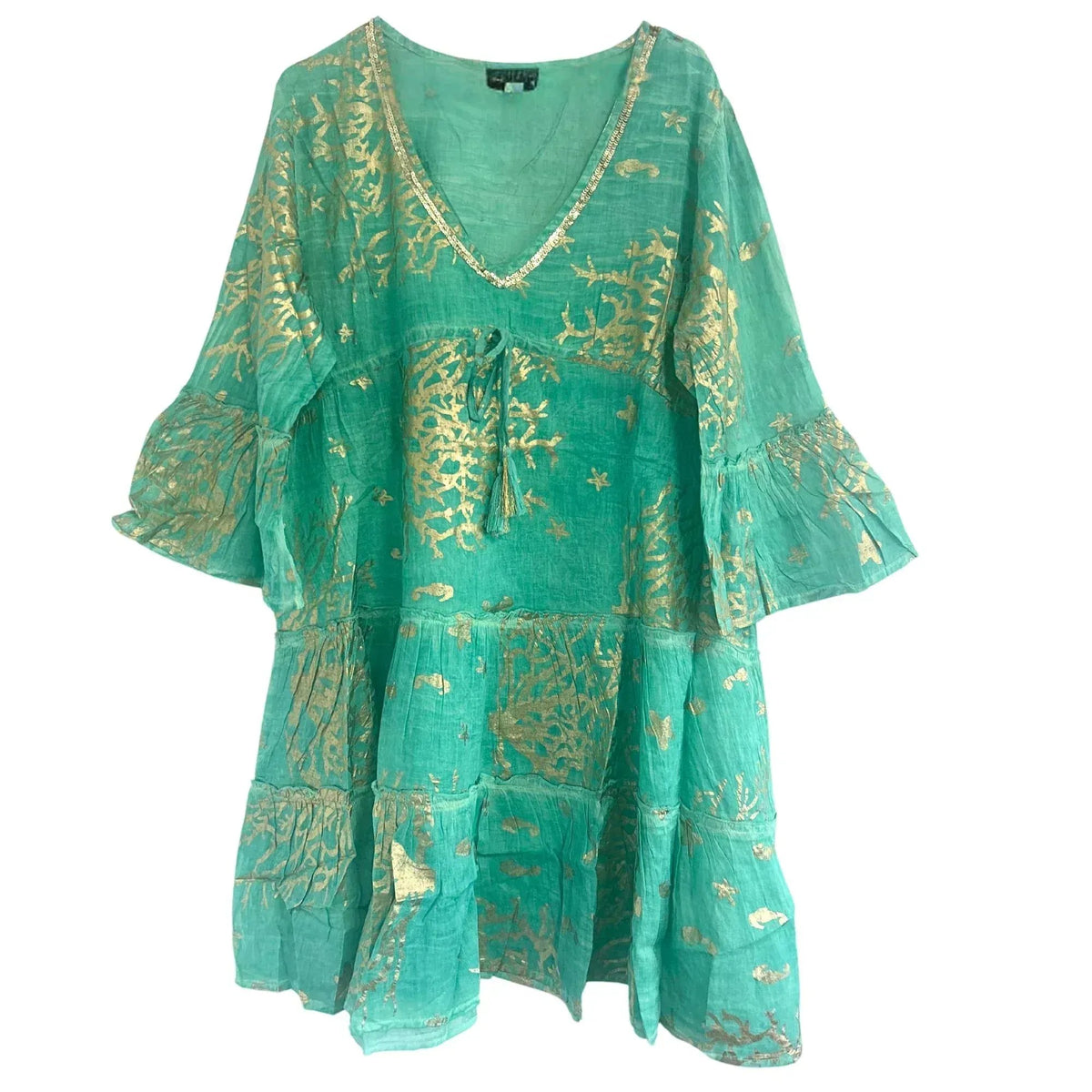 Vestido turquesa de corte holgado con volantes, cuello en V y estampado de corales dorados sobre tela ligera.