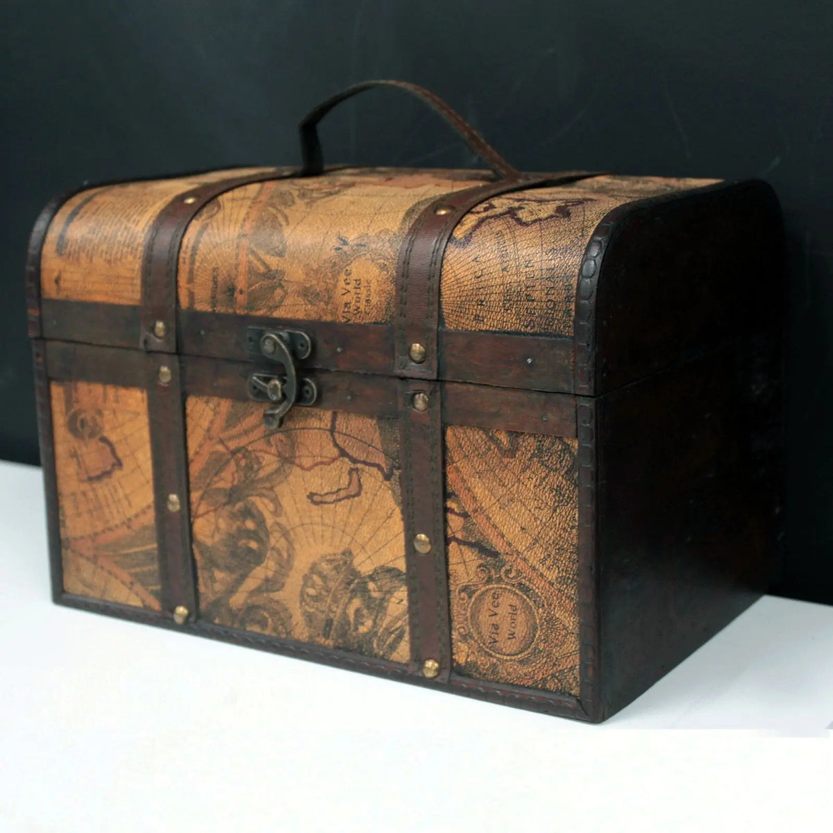 Cofre vintage de madera con estampado de mapa antiguo, detalles en cuero marrón, herrajes metálicos y asa superior.
