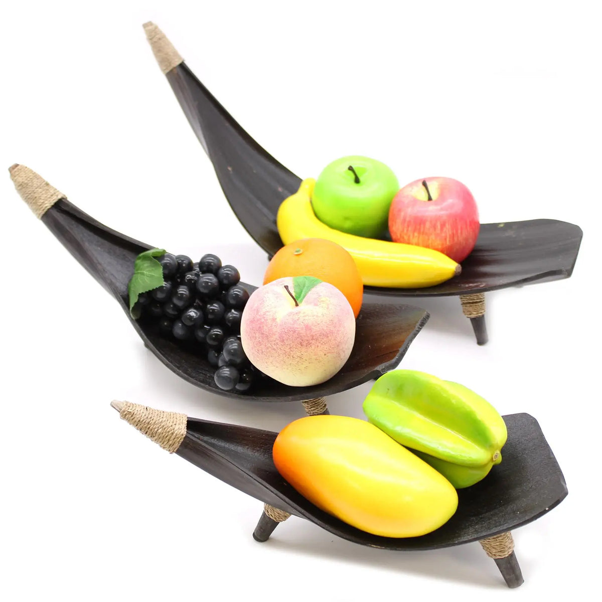 Set de 3 fruteros de hoja de coco color chocolate con detalles de cuerda, exhibiendo frutas artificiales variadas.