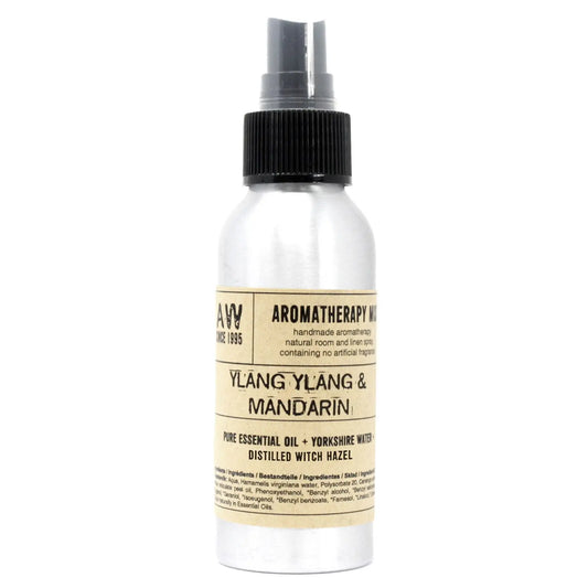 Botella de spray de aluminio con etiqueta de papel beige, tapón negro y texto impreso sobre aceite de ylang y mandarín.